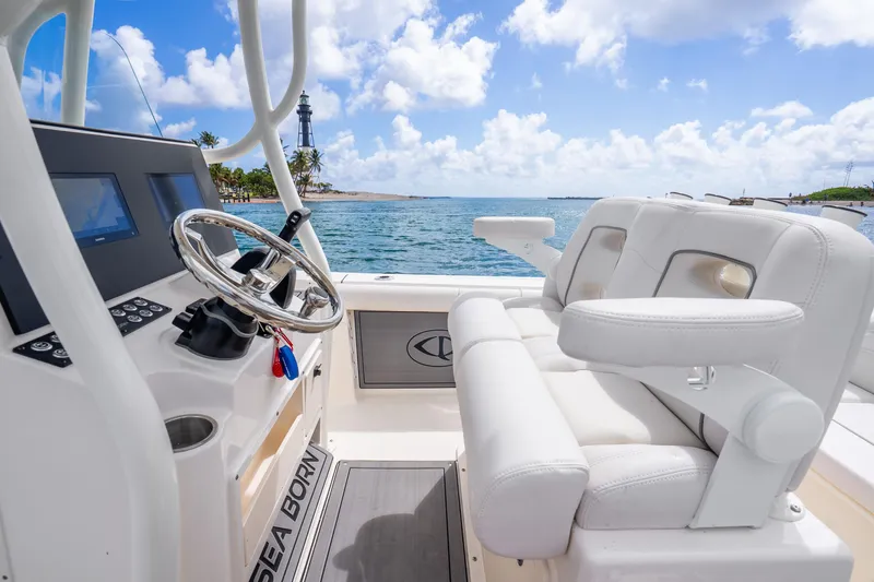 Slide: The Image of 2025 Sea Born LX22 Center Console boat interior with steering wheel and ocean view. - 25