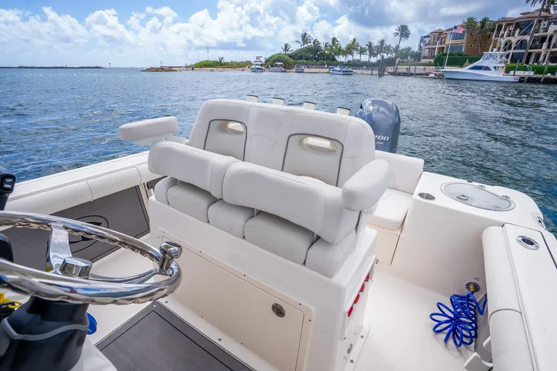 Slide: The Image of 2025 Sea Born LX22 Center Console boat interior with plush seating and scenic waterfront view. - 26