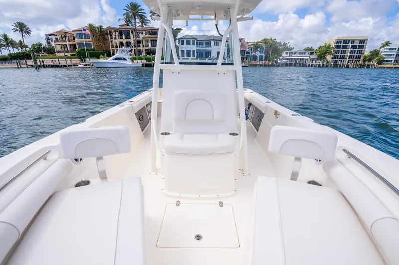 Slide: The Image of 2025 Sea Born LX22 Center Console boat on calm water, luxury waterfront homes in background. - 31