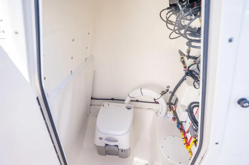 Slide: The Image of 2025 Sea Born LX22 Center Console interior with marine toilet and wiring. - 36