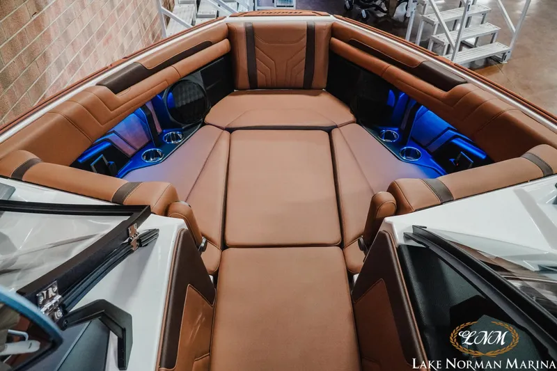 Slide: The Image of 2026 Malibu Wakesetter 25 LSV interior with luxurious brown seating and blue LED lighting. - 17