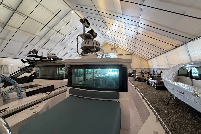 Slide: The Image of 2022 Axopar 28 Cabin boat in storage facility, surrounded by other boats and vehicles. - 10