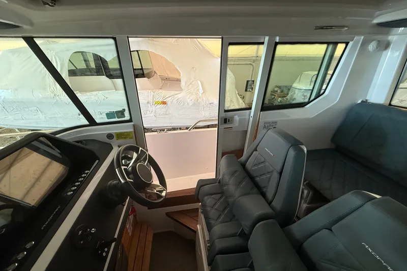 Slide: The Image of Interior of 2022 Axopar 28 Cabin boat, featuring modern seating and control panel. - 19
