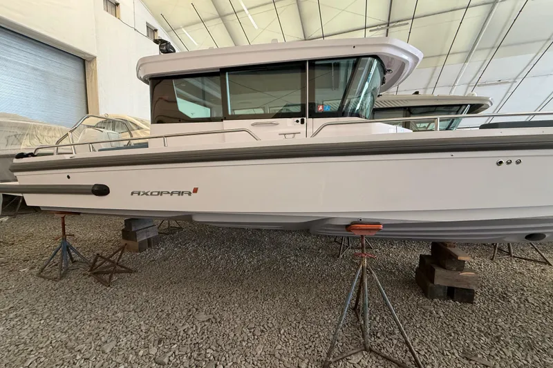 Slide: The Image of 2022 Axopar 28 Cabin boat elevated in storage facility. - 2