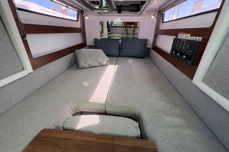 Slide: The Image of 2022 Axopar 28 Cabin interior with open storage and sink, featuring wood accents. - 22