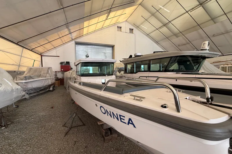 Slide: The Image of 2022 Axopar 28 Cabin boat in storage facility, surrounded by other covered boats. - 4