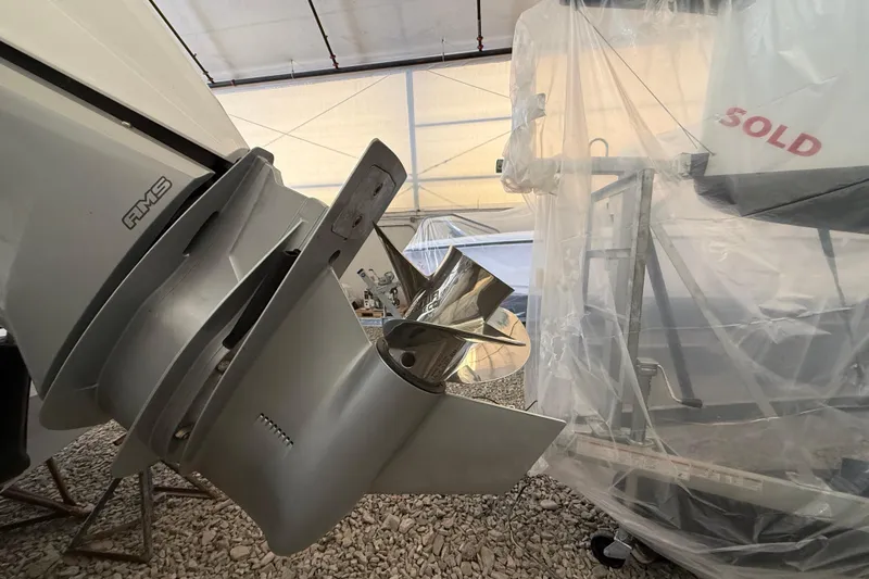 Slide: The Image of 2022 Axopar 28 Cabin boat propeller and engine detail in a covered storage area. - 8