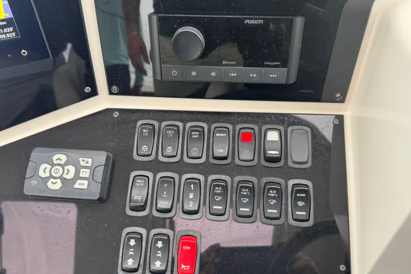 Slide: The Image of Control panel of a 2009 Carver 44 Sojourn yacht with various switches and a Fusion audio system. - 14