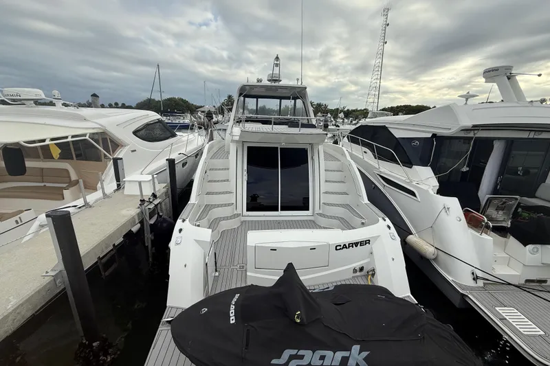 Slide: The Image of 2009 Carver 44 Sojourn yacht docked at marina, surrounded by other boats. - 16