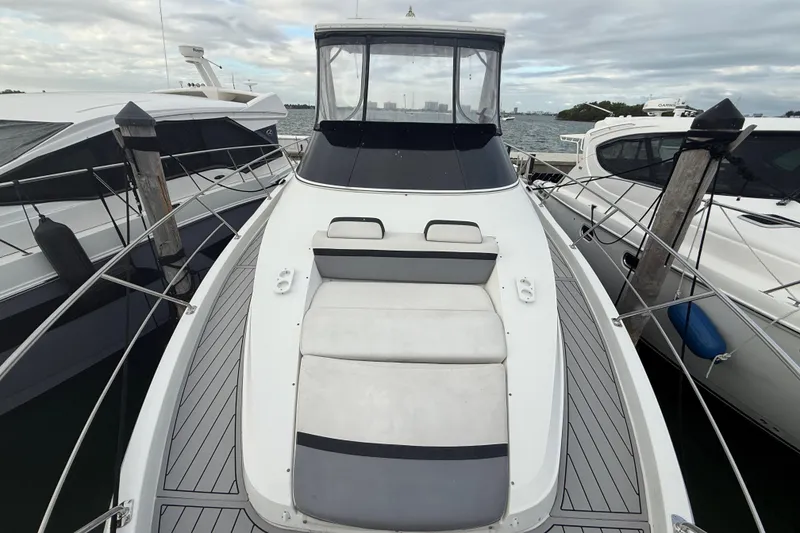 Slide: The Image of 2009 Carver 44 Sojourn yacht docked, showcasing sleek design and spacious deck. - 19