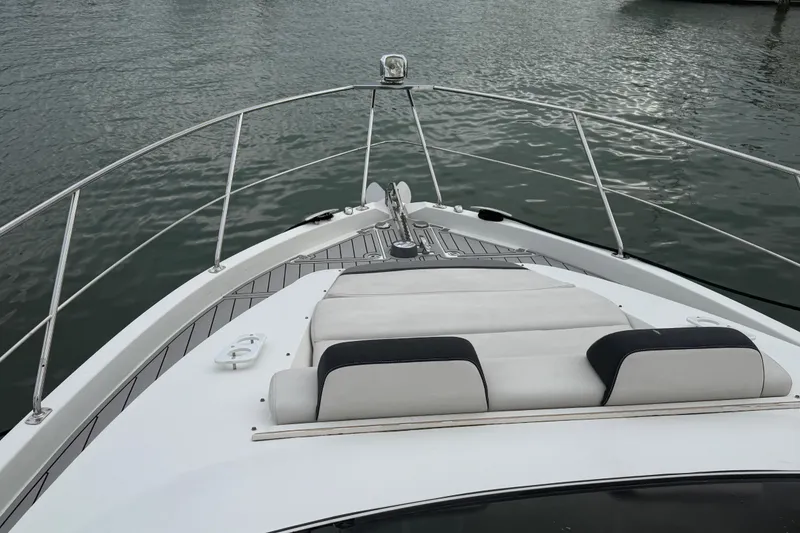 Slide: The Image of 2009 Carver 44 Sojourn yacht bow with cushioned seating, on calm water. - 20