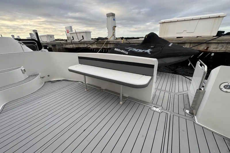 Slide: The Image of 2009 Carver 44 Sojourn yacht deck with bench seating and docked jet ski. - 26
