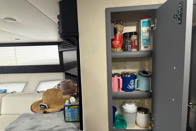 Slide: The Image of Interior of 2009 Carver 44 Sojourn with open cabinet displaying mugs and pantry items. - 34