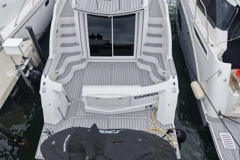 Slide: The Image of 2009 Carver 44 Sojourn yacht docked, featuring spacious deck and sleek design. - 9