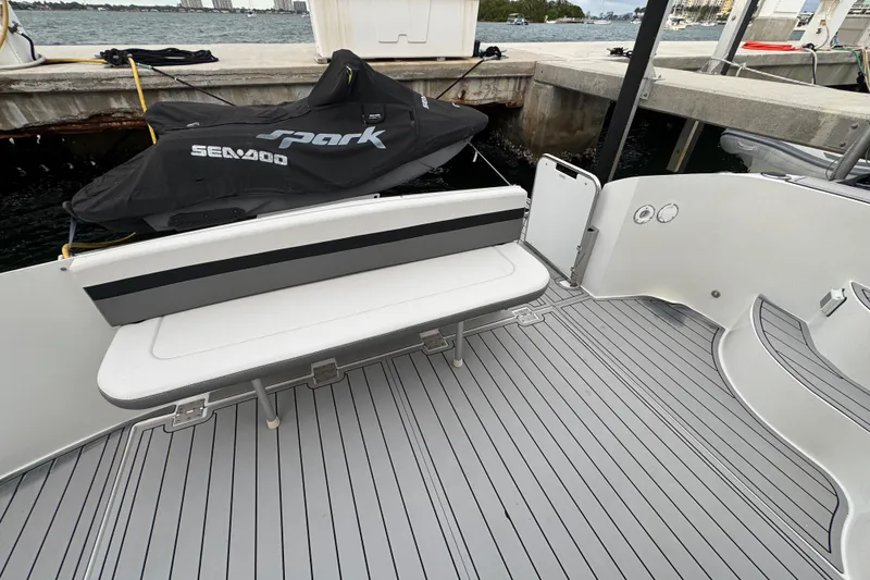 Slide: The Image of 2009 Carver 44 Sojourn yacht deck with bench seating and docked Sea-Doo. - 27