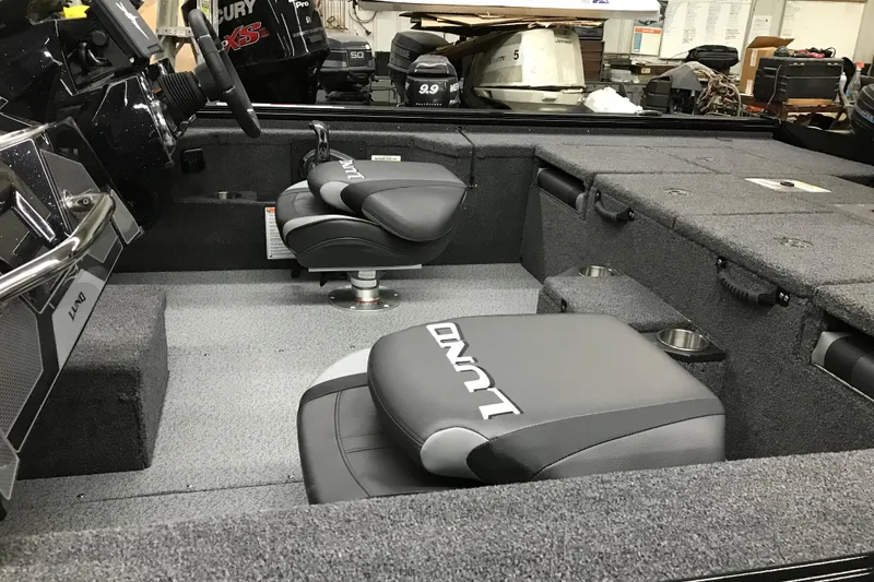 Slide: The Image of 2026 Lund 1875 Pro-V Bass XS boat interior with cushioned seats and storage compartments. - 11
