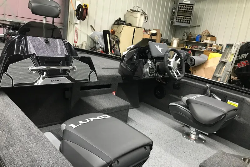 Slide: The Image of 2026 Lund 1875 Pro-V Bass XS boat interior with sleek seating and modern dashboard. - 12