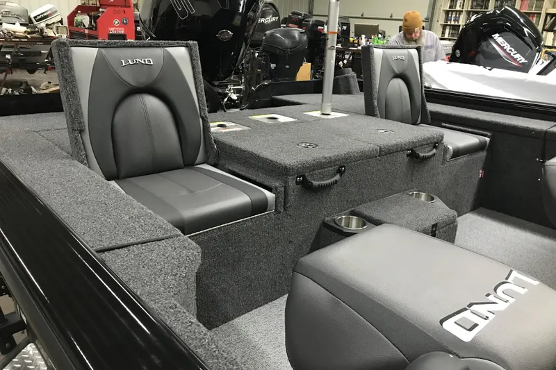 Slide: The Image of 2026 Lund 1875 Pro-V Bass XS boat interior with gray seating and storage compartments. - 14