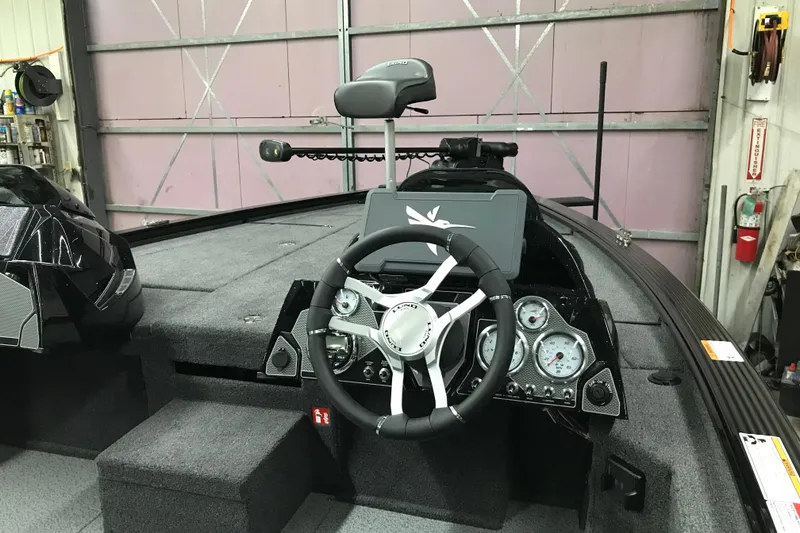 Slide: The Image of 2026 Lund 1875 Pro-V Bass XS boat interior with steering wheel and control panel. - 17