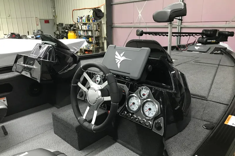 Slide: The Image of 2026 Lund 1875 Pro-V Bass XS boat interior with steering wheel and control panel. - 18