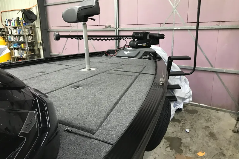 Slide: The Image of 2026 Lund 1875 Pro-V Bass XS boat in garage, featuring a Minn Kota trolling motor. - 19