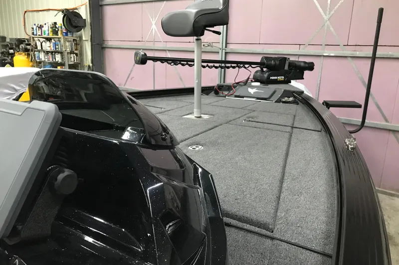 Slide: The Image of 2026 Lund 1875 Pro-V Bass XS boat with Minn Kota trolling motor in a garage. - 21