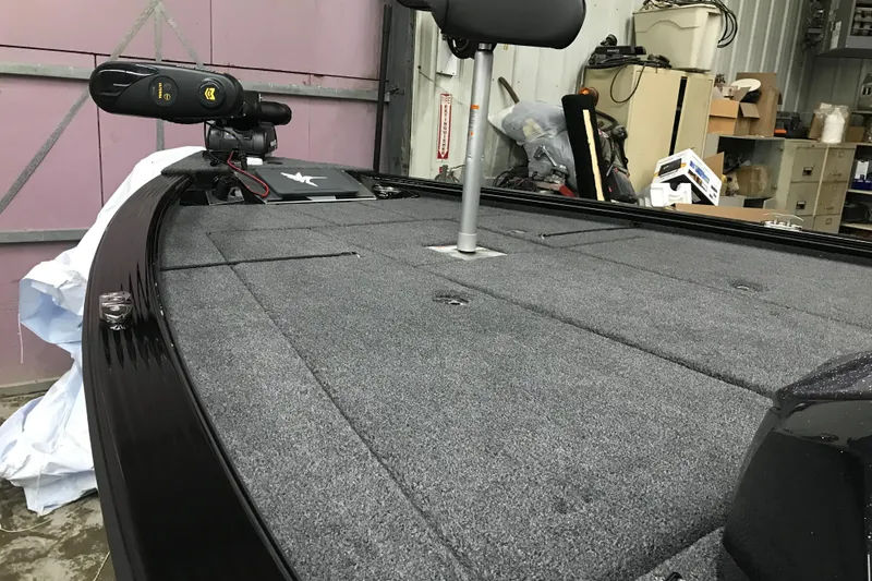 Slide: The Image of 2026 Lund 1875 Pro-V Bass XS boat interior with carpeted deck and fishing seat. - 9