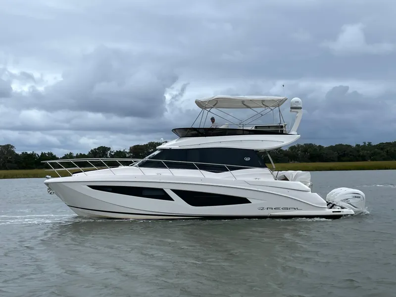 Slide: The Image of 2022 Regal 42 FXO yacht cruising on a cloudy day. - 1