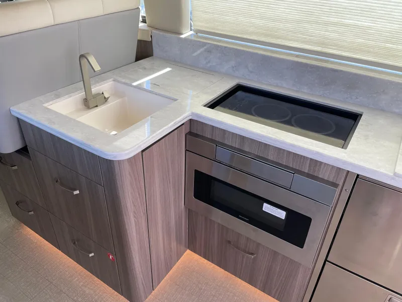 Slide: The Image of Modern kitchen in 2022 Regal 42 FXO yacht with sink, stove, and microwave. - 12