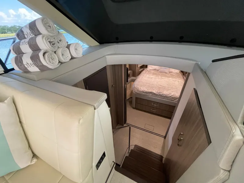 Slide: The Image of Interior of 2022 Regal 42 FXO yacht with cozy bedroom and stacked towels. - 14