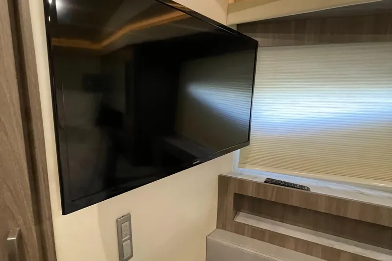 Slide: The Image of Interior of 2022 Regal 42 FXO yacht with mounted TV and window shade. - 18