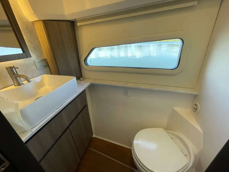 Slide: The Image of 2022 Regal 42 FXO yacht bathroom with modern sink, toilet, and window. - 31