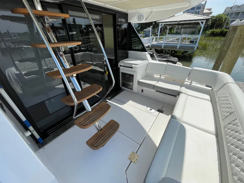 Slide: The Image of 2022 Regal 42 FXO yacht interior with modern seating and wooden stairs. - 40