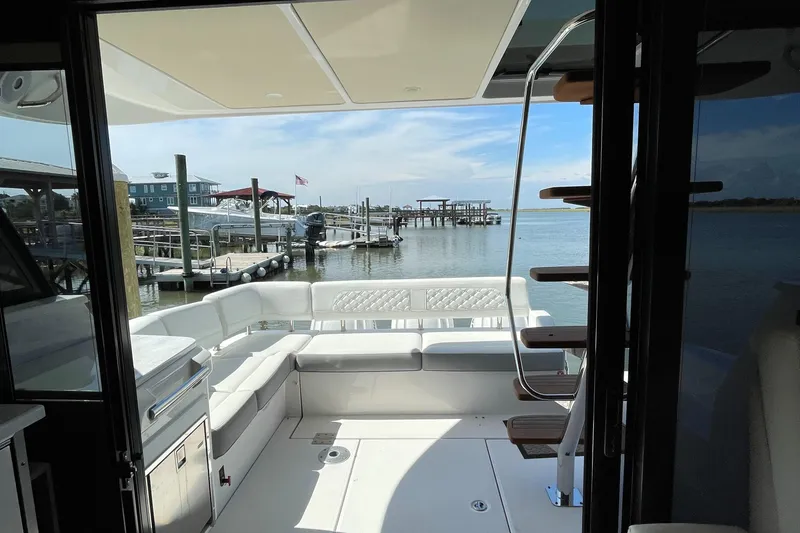 Slide: The Image of 2022 Regal 42 FXO yacht interior with waterfront view and seating area. - 41