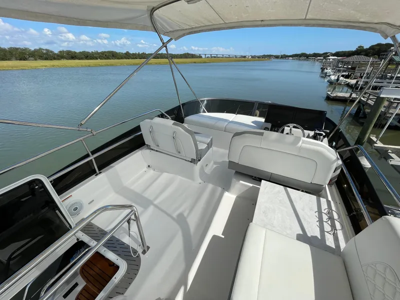 Slide: The Image of 2022 Regal 42 FXO yacht with spacious deck overlooking serene marina. - 47