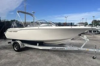 Slide: The Image of 2024 Key West 203 DFS boat on trailer, parked outdoors under clear sky. - 1