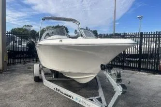 Slide: The Image of 2024 Key West 203 DFS boat on trailer, parked outdoors. - 2