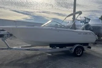 Slide: The Image of 2024 Key West 203 DFS boat on trailer, parked outdoors under cloudy sky. - 4