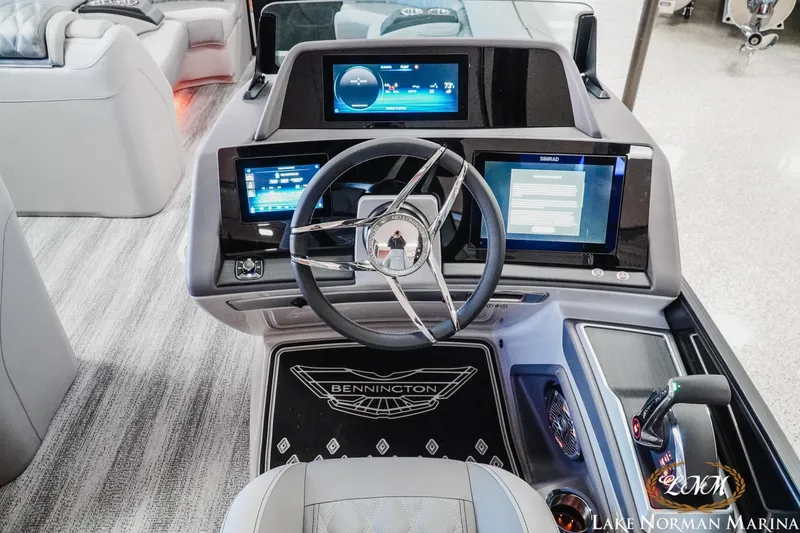 Slide: The Image of 2026 Bennington 25QSBA boat dashboard with advanced digital displays and steering wheel. - 11