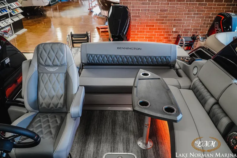 Slide: The Image of 2026 Bennington 25QSBA boat interior with luxurious seating and table at Lake Norman Marina. - 16