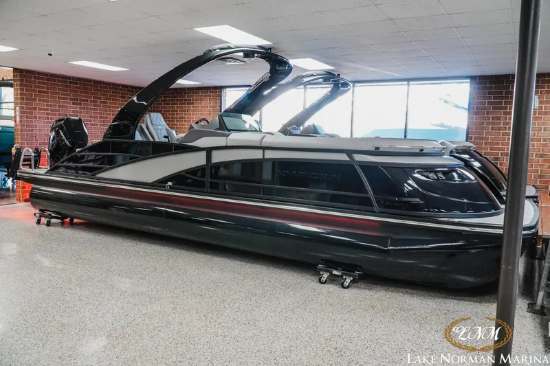 Slide: The Image of 2026 Bennington 25QSBA pontoon boat displayed indoors at Lake Norman Marina. - 2