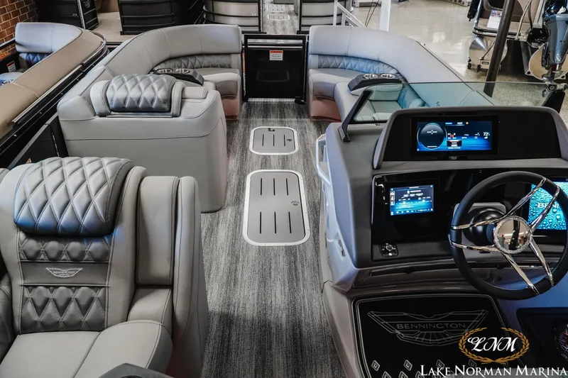 Slide: The Image of Luxurious interior of 2026 Bennington 25QSBA pontoon boat with modern dashboard and plush seating. - 9