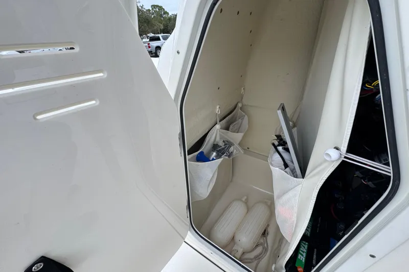 Slide: The Image of 2024 Key West 250 Bay Reef storage compartment with organized gear and equipment. - 13