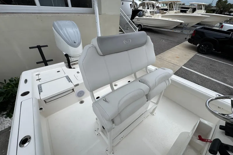 Slide: The Image of 2024 Key West 250 Bay Reef boat interior with white seating and steering wheel. - 17