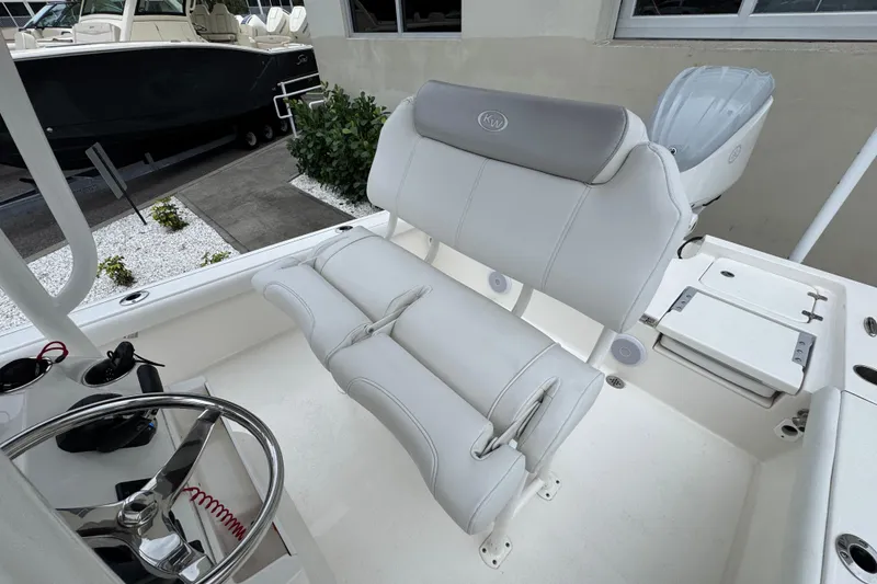 Slide: The Image of 2024 Key West 250 Bay Reef boat interior with white seating and steering wheel. - 18