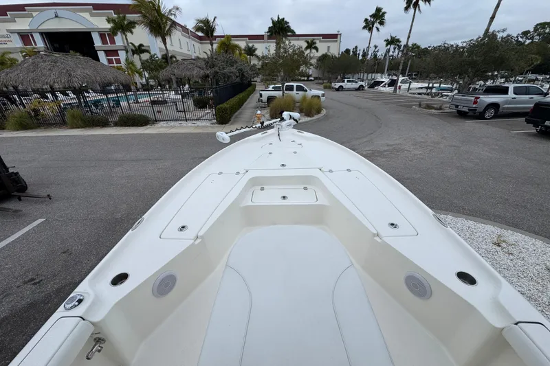 Slide: The Image of 2024 Key West 250 Bay Reef boat in parking lot with palm trees and buildings. - 2