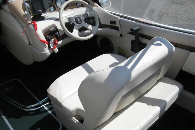 Slide: The Image of Interior of a 1997 Regal 2100 LSR boat with white seating and steering wheel. - 12