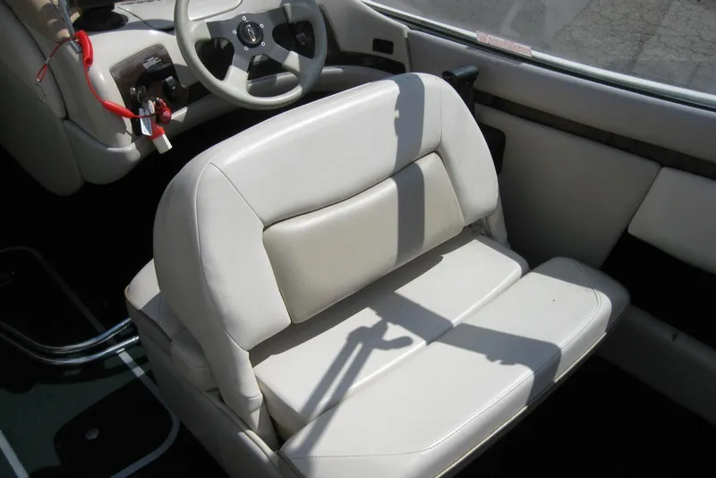 Slide: The Image of Interior of a 1997 Regal 2100 LSR boat with white seating and steering wheel. - 13
