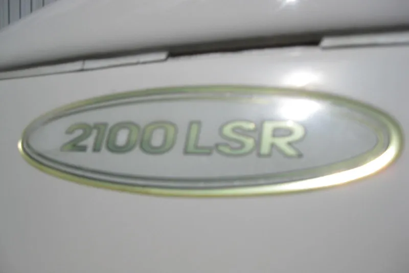Slide: The Image of 1997 Regal 2100 LSR boat emblem on white surface. - 4