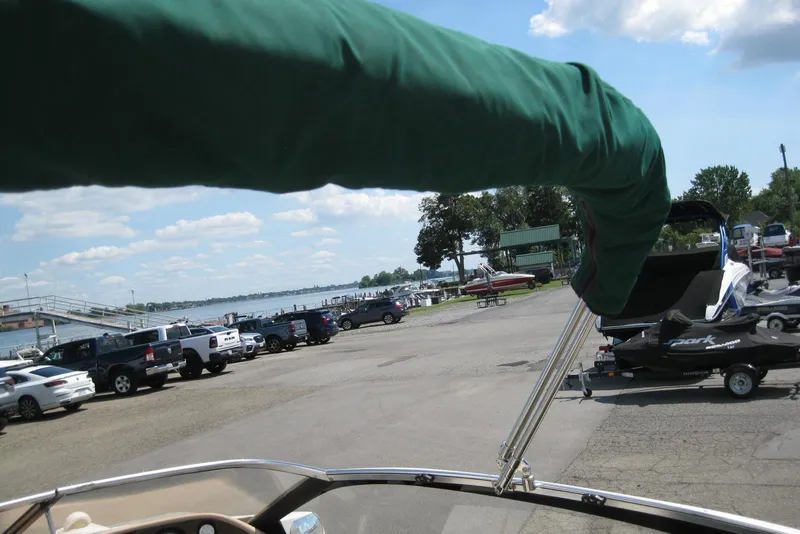 Slide: The Image of 1997 Regal 2100 LSR boat at a lakeside parking area with trailers and vehicles. - 9